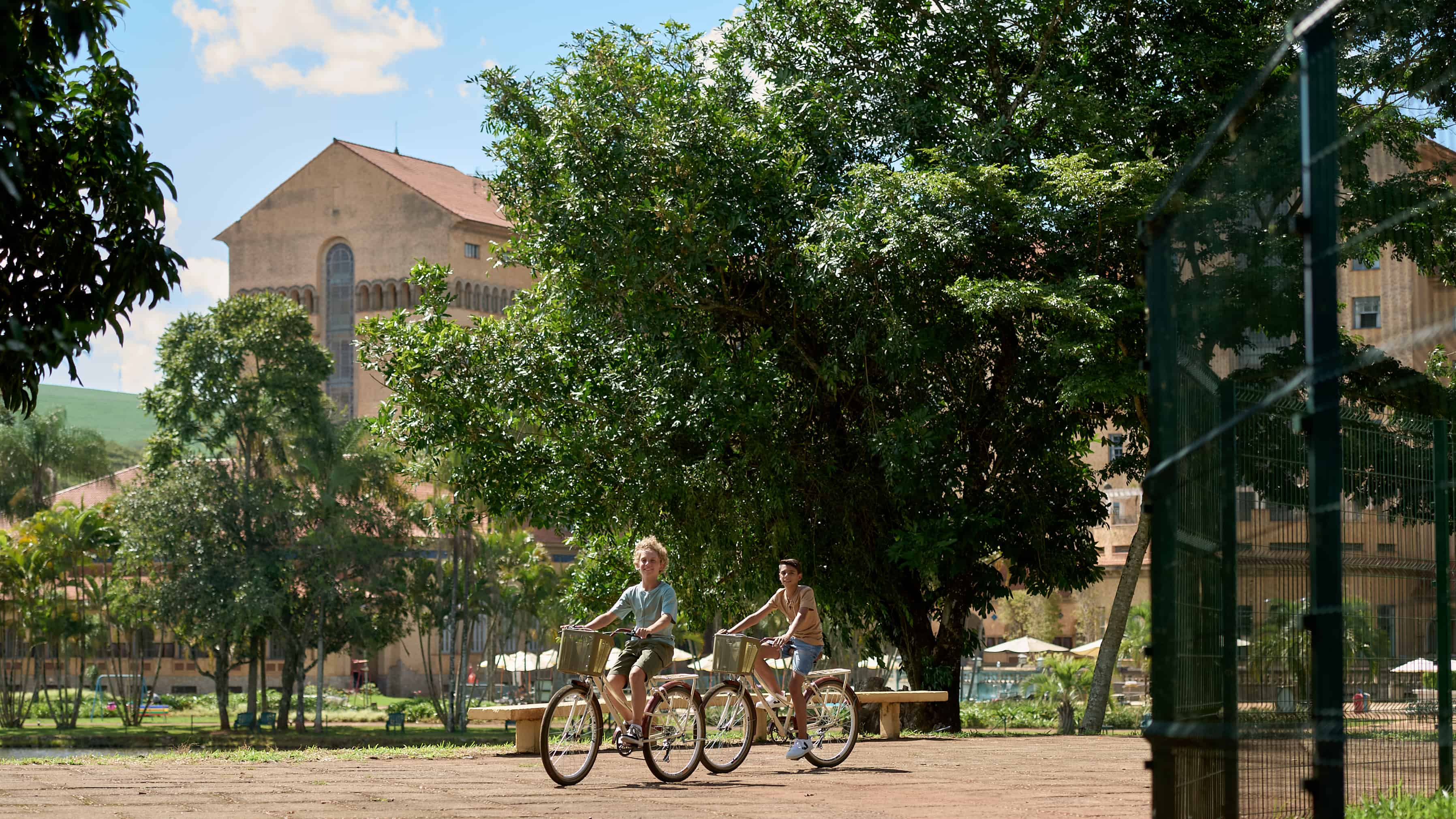 Duas crianças andam de bicicleta em frente à fachada do hotel